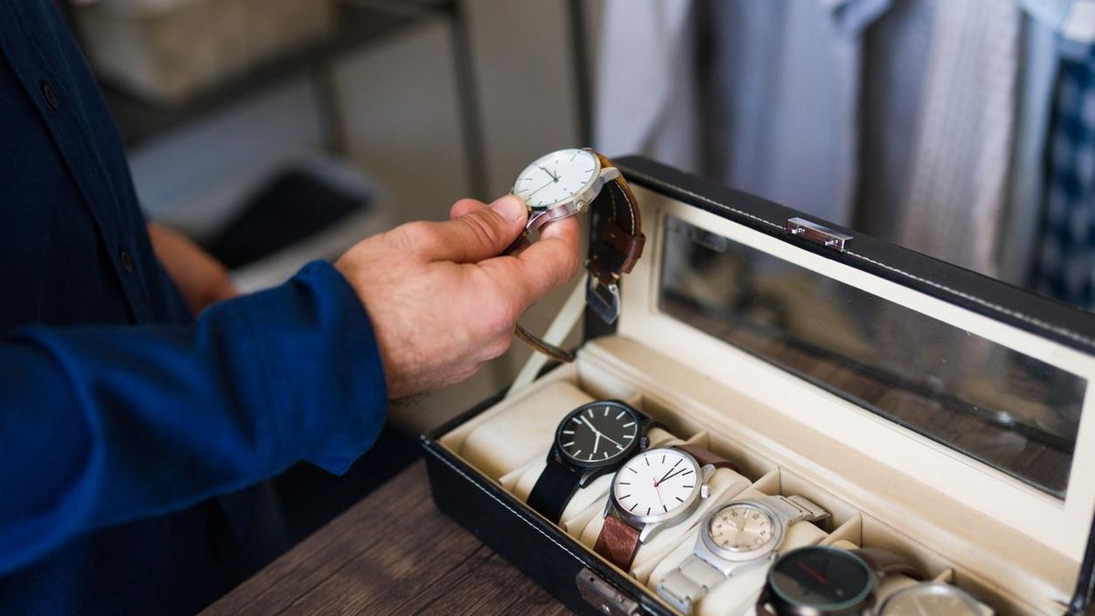 Un hombre elige un reloj entre diferentes modelos.
