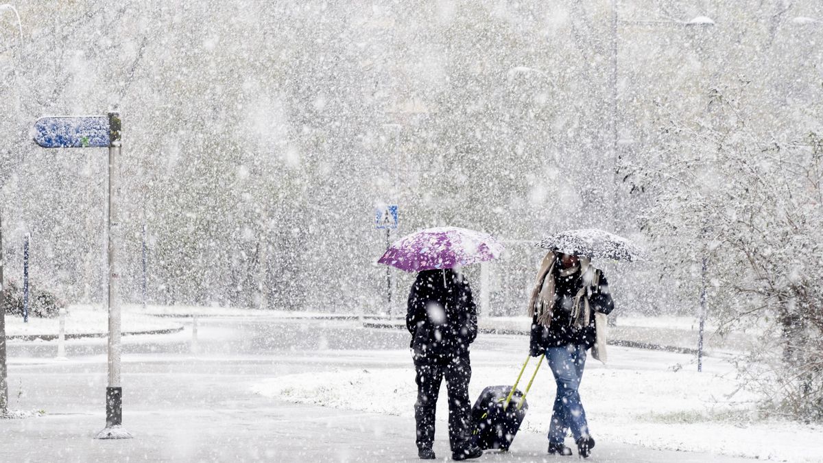 Archivo - Paseantes cubiertos de nieve el pasado mes de noviembre en Vitoria.