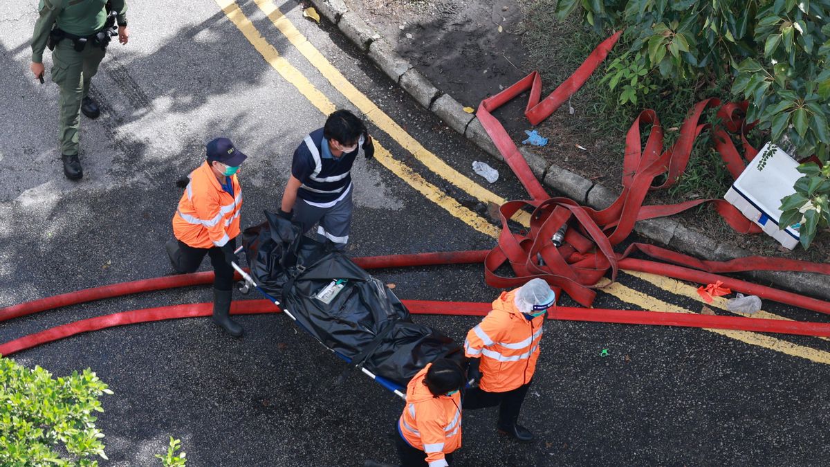 Los servicios de emergencia trasladan un cuerpo en el lugar del incendio de los apartamentos Tai Po en Hong Kong,