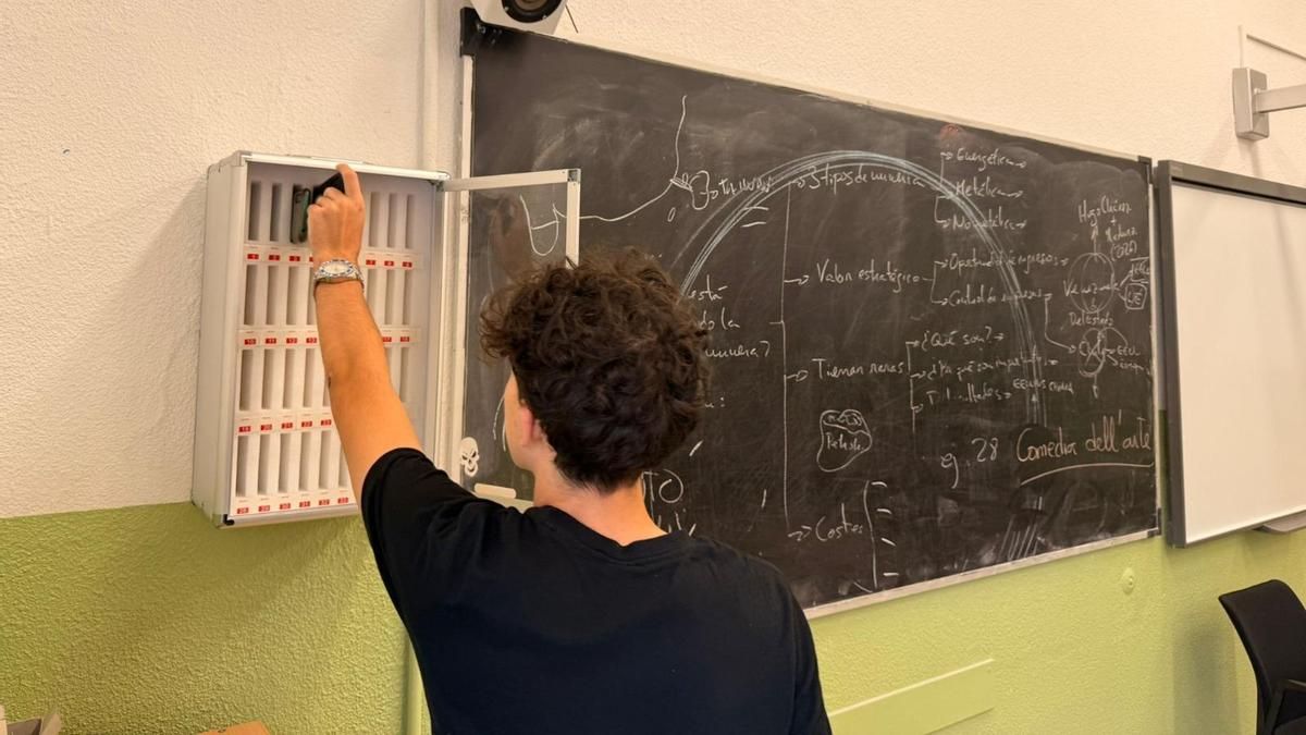 Un alumno deja su teléfono móvil en el armario de un aula del Colegio Ferroviario.