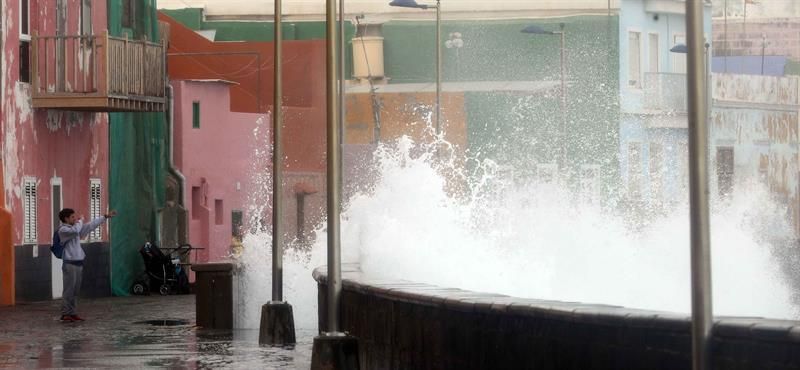 Un joven fotografía el fuerte oleaje en el barrio de San Cristóbal como consecuencia del temporal de viento que afecta a las Islas Canarias.