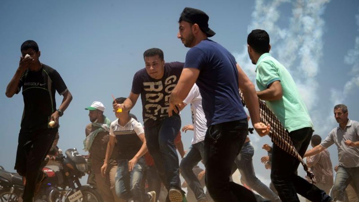 Manifestantes palestinos huyen del ejército israelí durante las protestas en la frontera entre Gaza e Israel.
