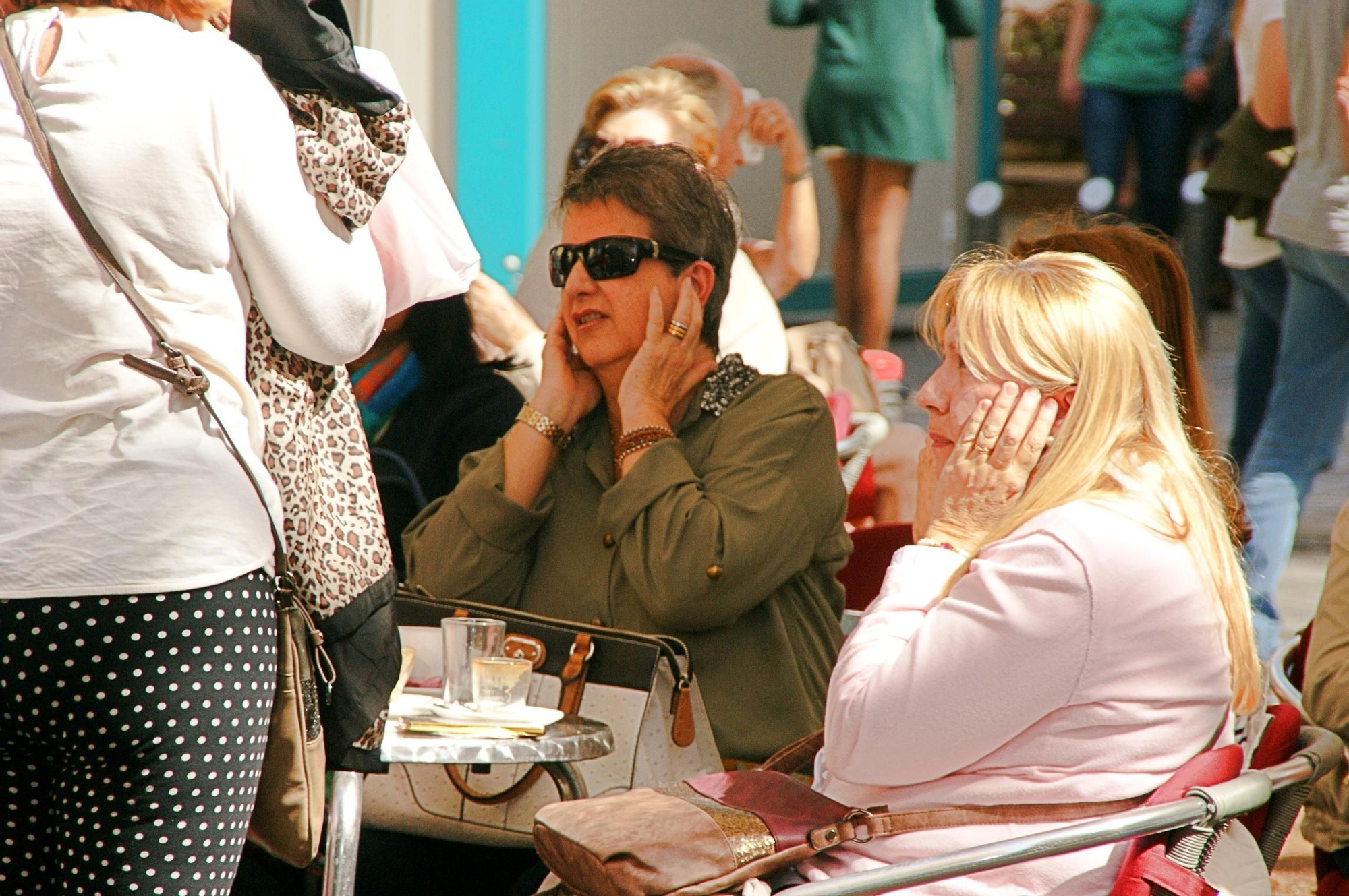 Varias mujeres se tapan los oídos al paso de la marcha de bomberos y estibadores