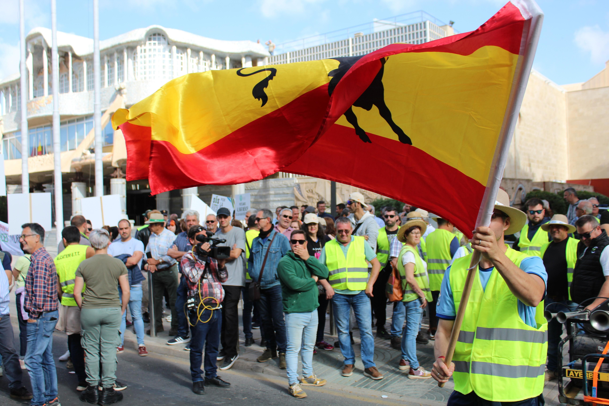 Un agricultor zarandea una bandera española con un toro negro en el centro