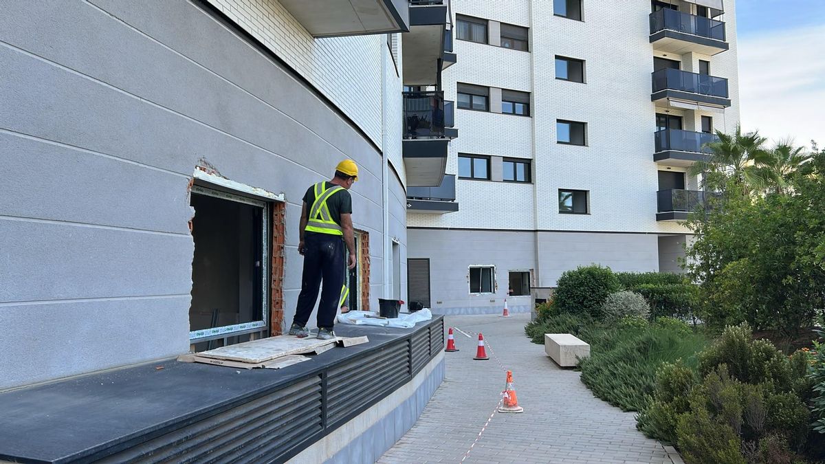 Un operari accedeix a les zones comunes per la finestra instal·lada sense permís de la comunitat del carrer Encarna Albarracín.