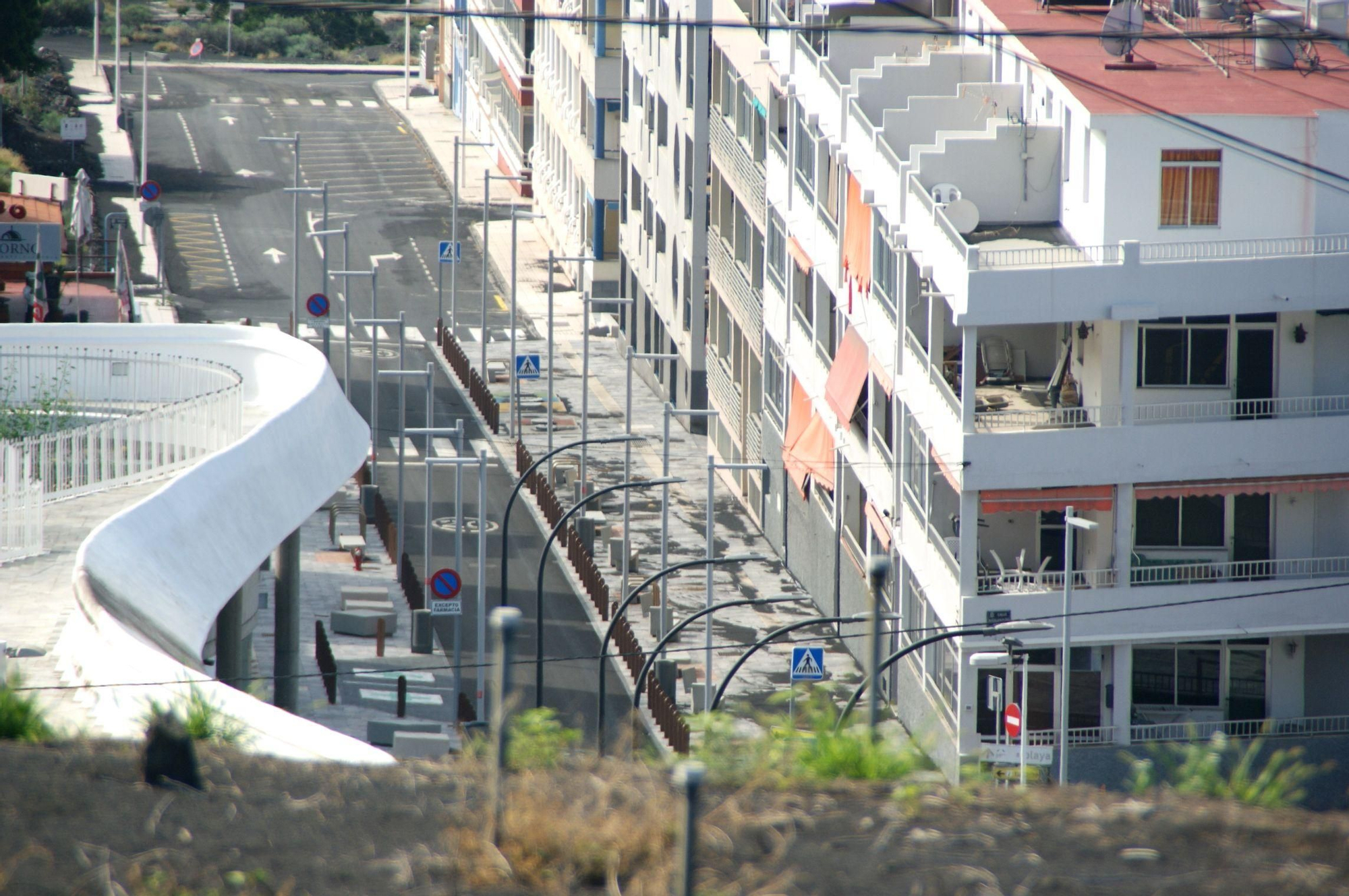 Una de las avenidas de Puerto Naos, aún con ceniza en sus aceras, sigue aguardando el regreso de sus habitantes, evacuados por los gases volcánicos