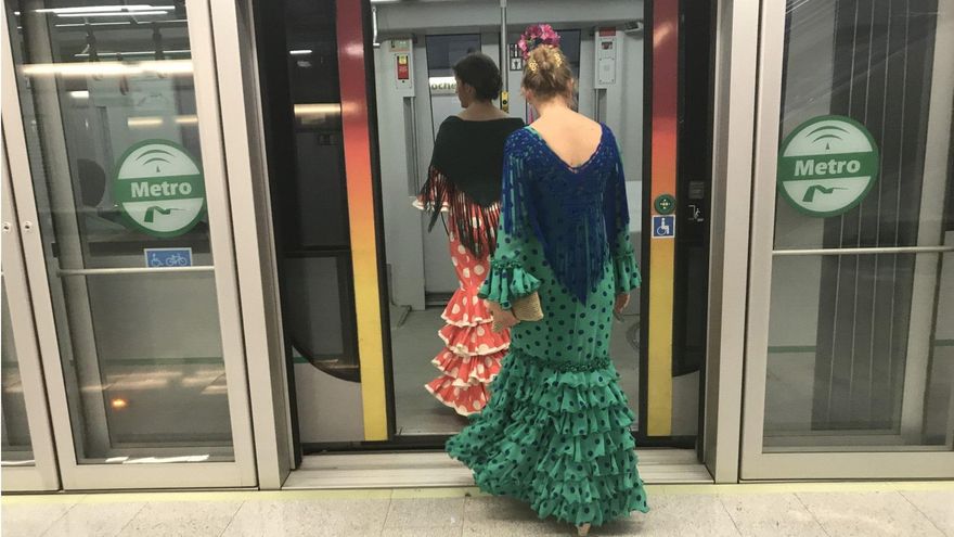Mujeres vestidas de flamenca acceden al interior de uno de los vagones del metro.