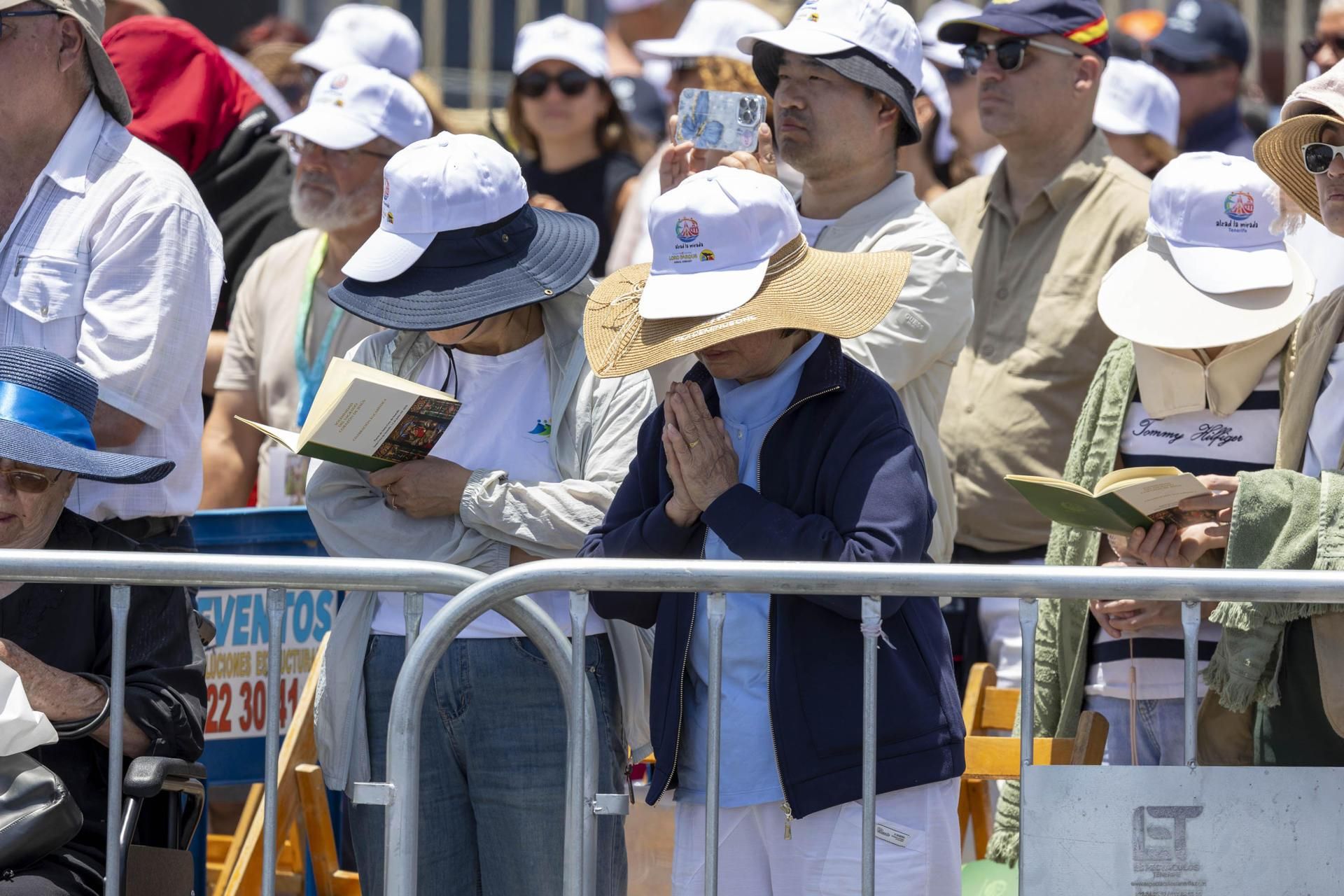 Gorras, agua y mucha crema solar para aguantar el sol y el calor durante la misa.