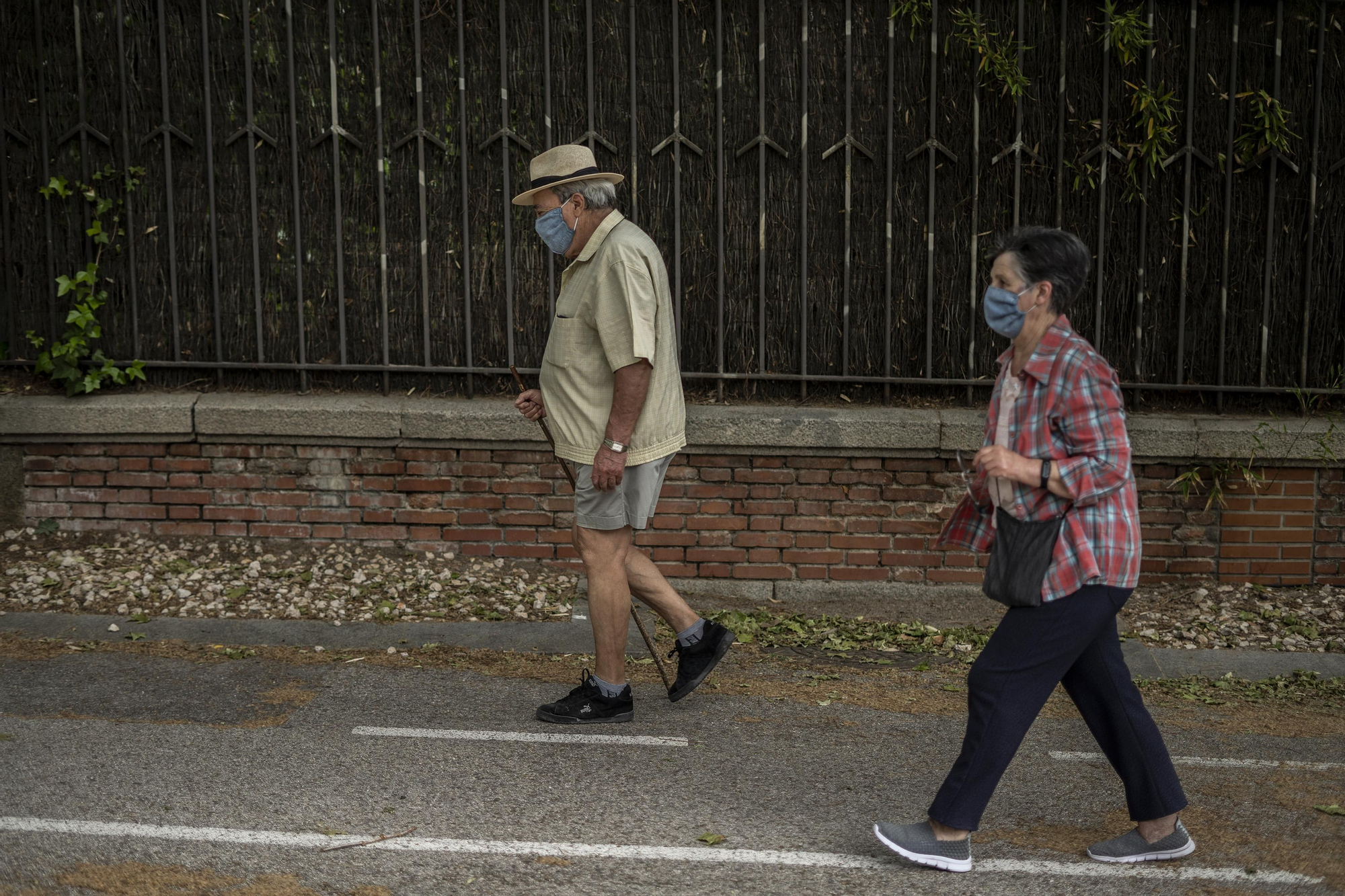 Una pareja pasean ambos con mascarillas