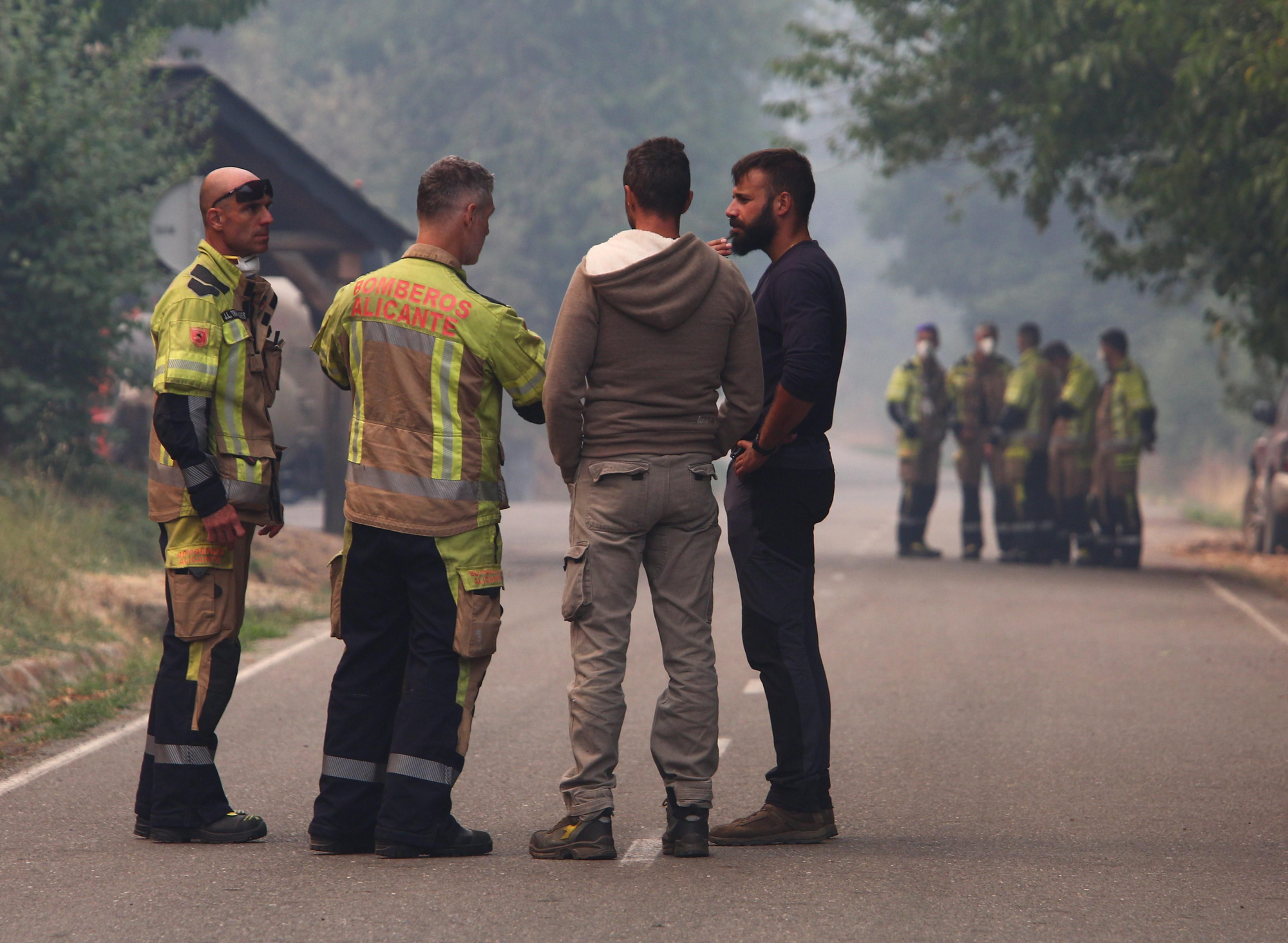 Vecinos charlan con personal de extinción desplazado de emergencia a León.