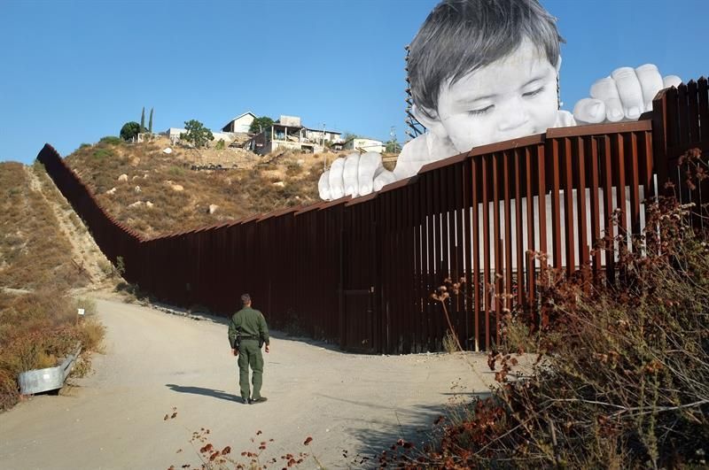 Un artista francés levanta a un niño gigante entre la frontera de EE.UU. y México