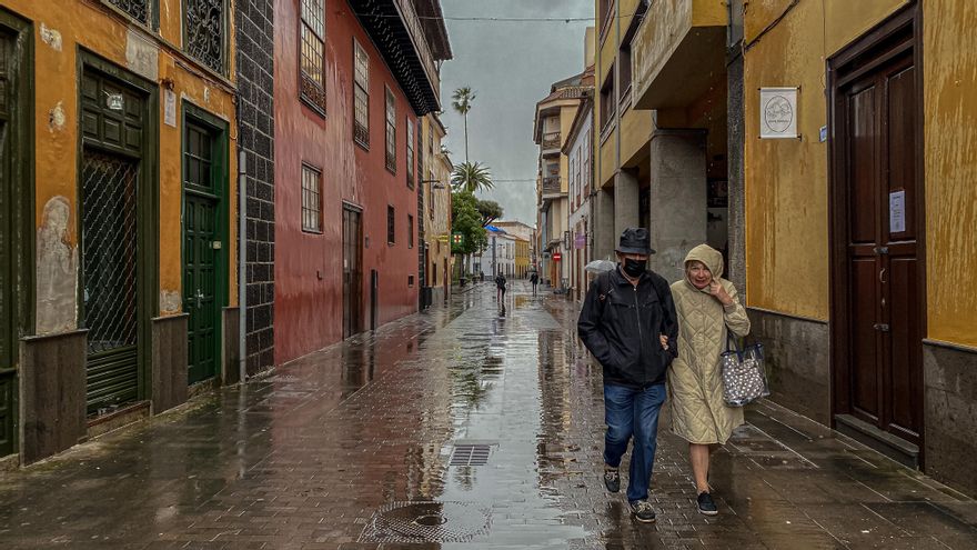 Dos personas se resguardan del frío este lunes en La Laguna.