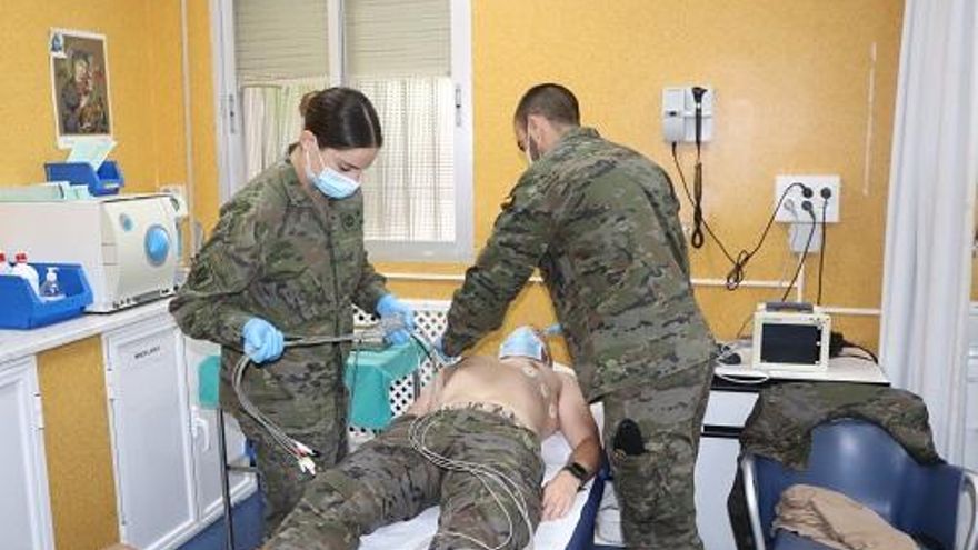 En la imagen superior, dos Oficiales Enfermeros realizando un electrocardiograma a un soldado en las instalaciones de Enfermería de la base cordobesa de Cerro Muriano.