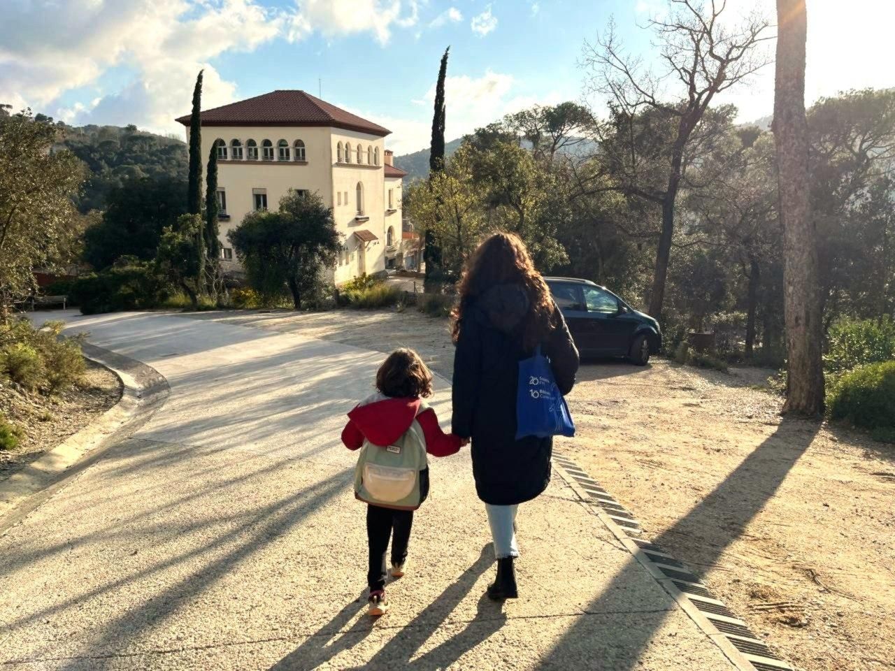 Joana y su madre, pasean por el entorno de la escuela Els Xiprers, al fondo