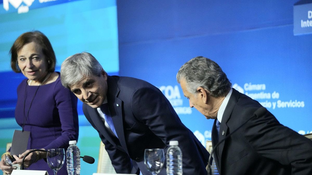 Caputo se agacha para acomodarse en el escenario del Council of the Americas, junto a Susan Segal y Mario Grinman, la semana pasada.