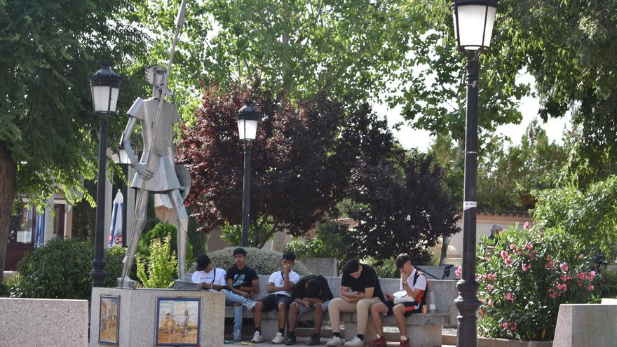 Varios jóvenes descansan en un banco tras una noche de fiesta en Cobisa (Toledo) el 23J