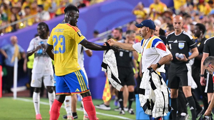 El futbolista Davinson Sánchez, de Colombia, recibe un chaleco de enfriamiento durante una pausa de hidratación en el partido de su selección frente a Ghana.