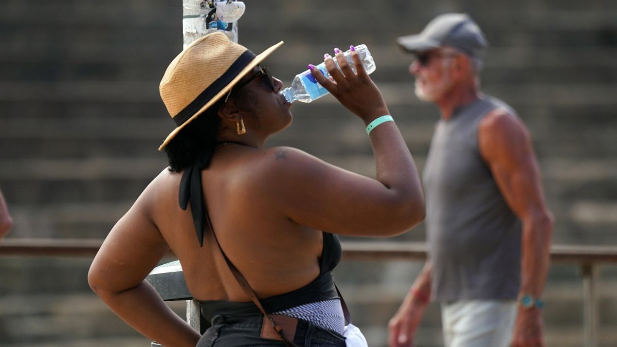 Una mujer bebiendo agua.
