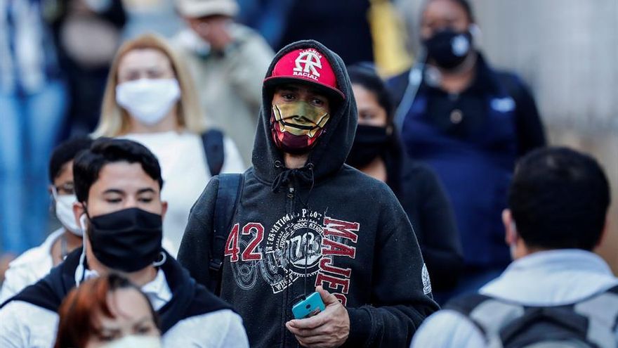 Personas con tapabocas caminan por una calle en Sao Paulo (Brasil)
