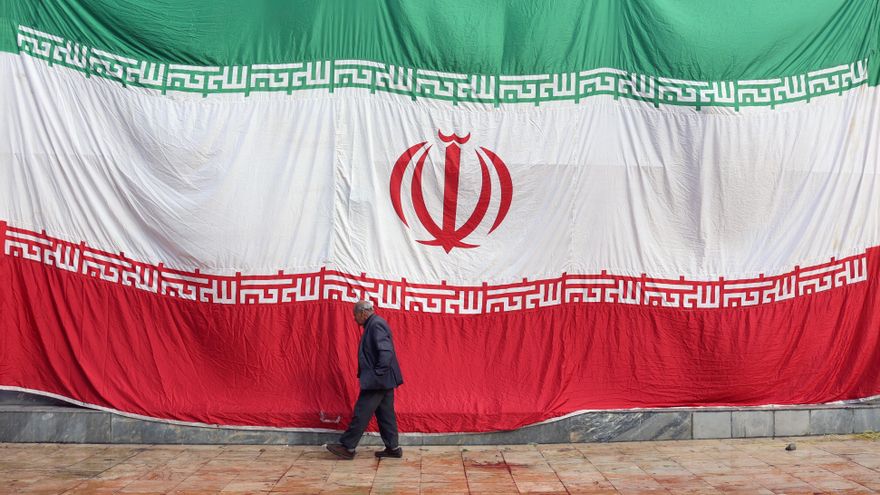 Un hombre pasa delante de una enorme bandera iraní, en una imagen de archivo. EFE/EPA/ABEDIN TAHERKENAREH