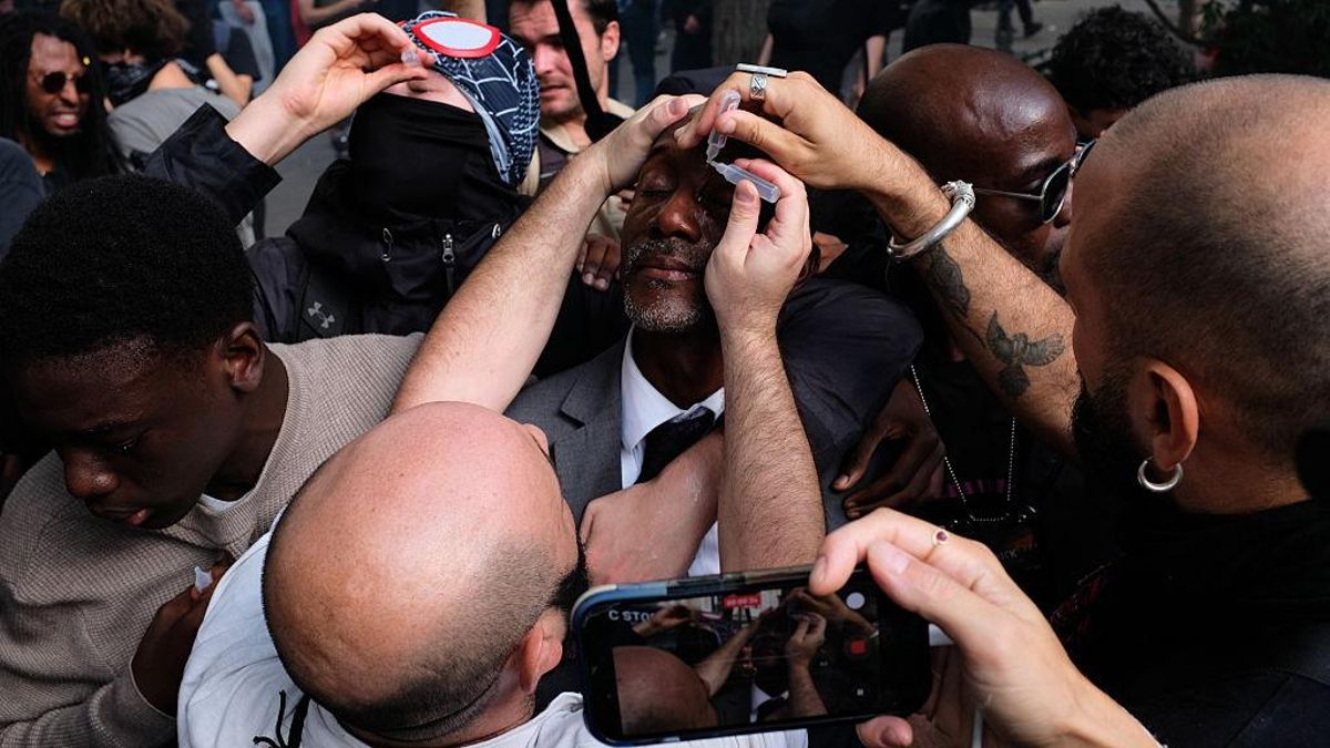 Varias personas lavan los ojos de Bally Bagayoko, alcalde de Saint-Denis y diputado francés de La France Insoumise, con líquido procedente de pequeños frascos de plástico durante una manifestación estudiantil.