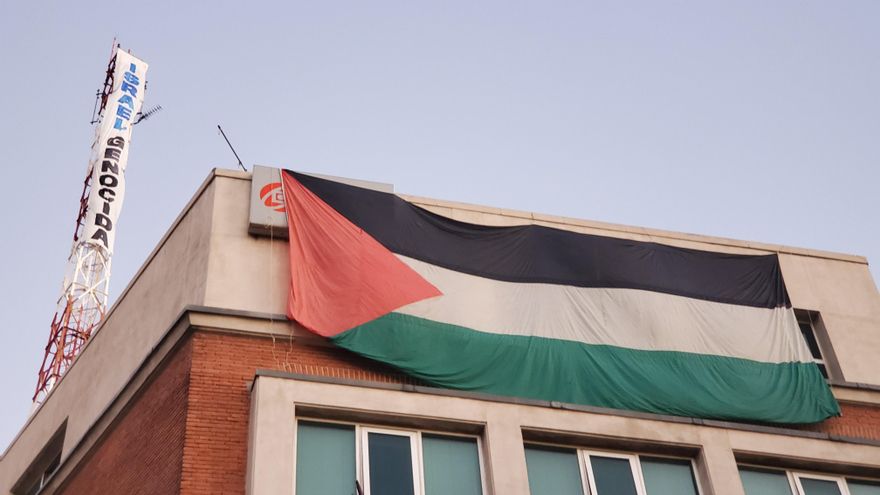Activistas despliegan una bandera de Palestina y una pancarta frente a la embajada de Israel en Madrid