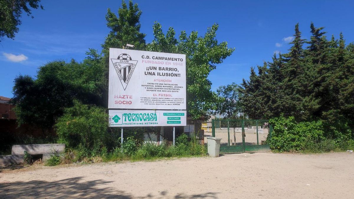 Entrada al campo de tierra del C.D. Campamento, con un anuncio de una inmobiliaria.