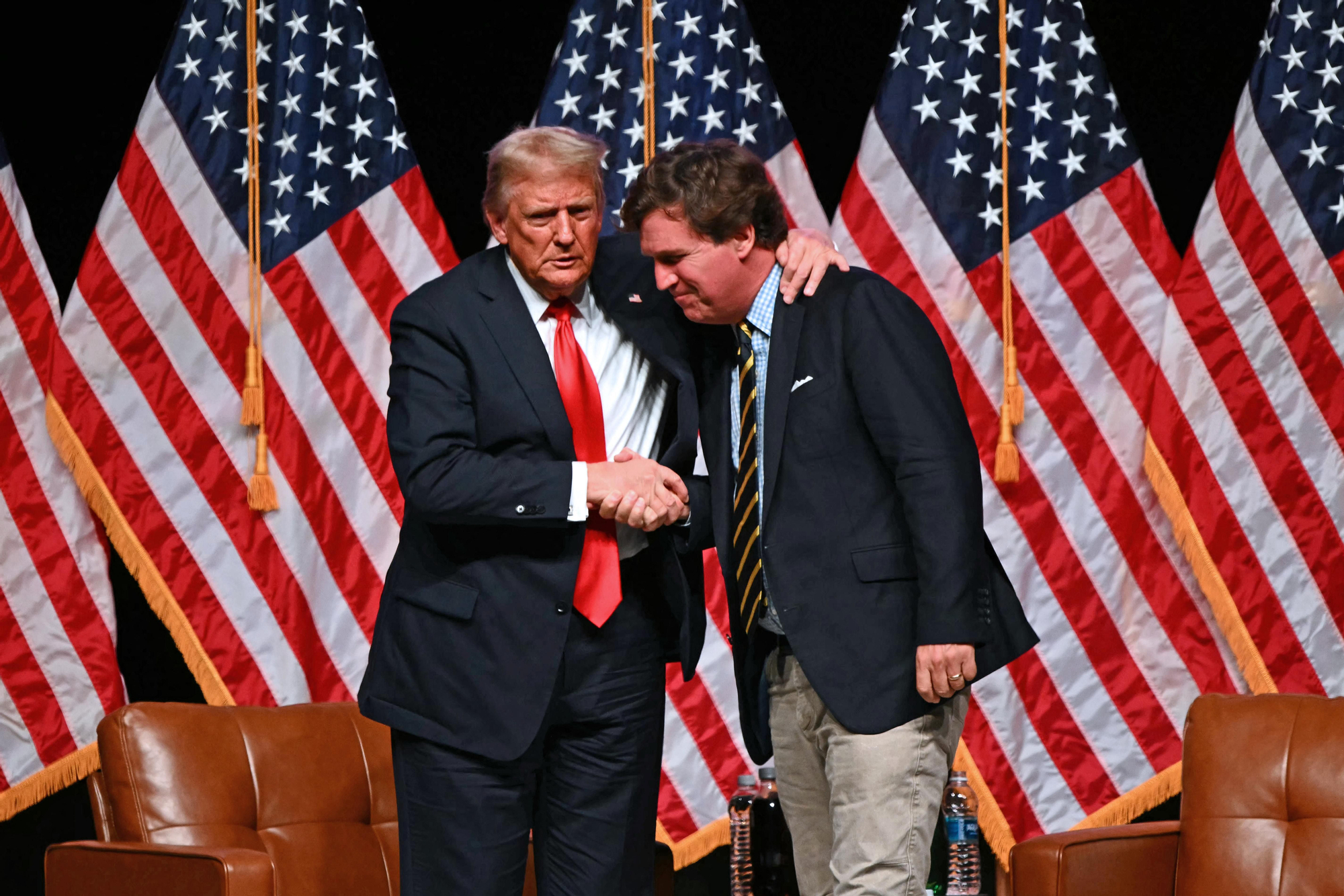Donald Trump y Tucker Carlson al final de una entrevista en el Desert Diamond Arena en Glendale, Arizona, el 31 de octubre de 2024.