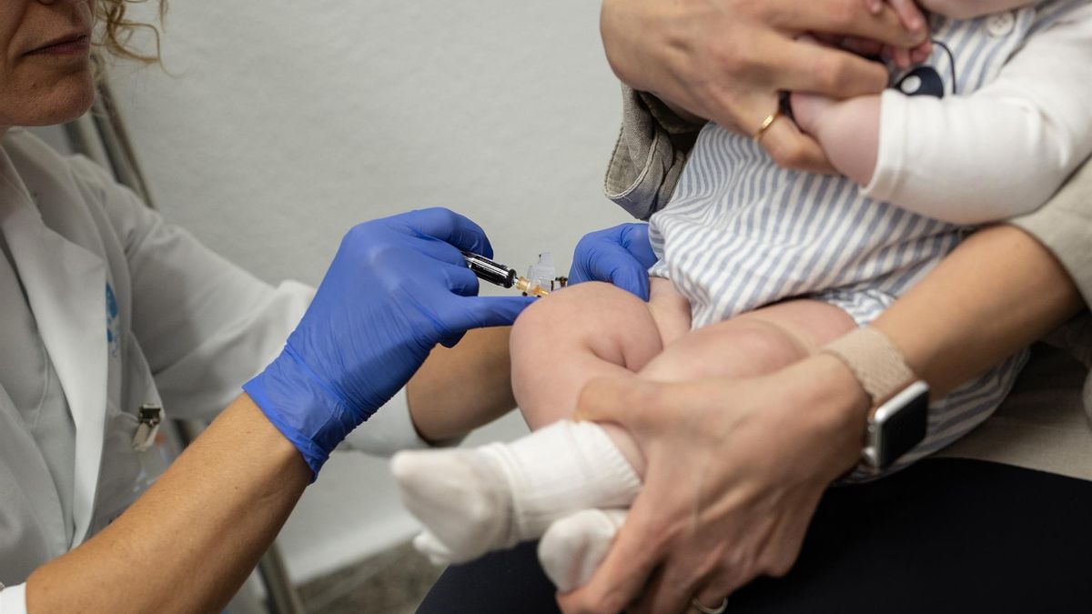 Una sanitaria vacuna a un bebé en imagen de archivo | EP