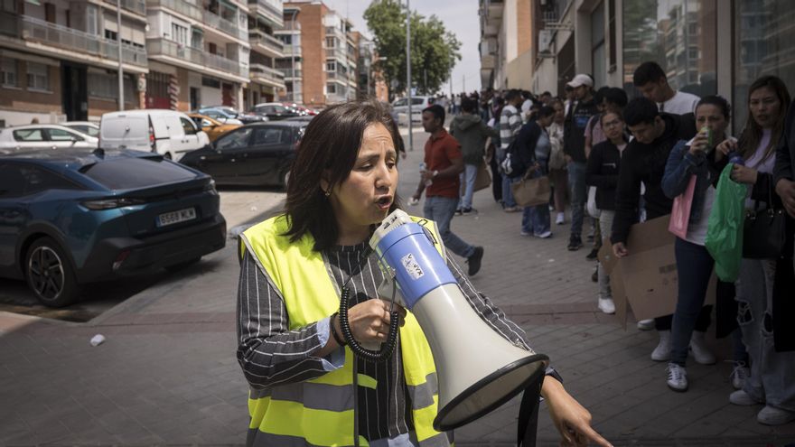 Elizabeth Sánchez, miembro de la ONG Rumiñahui, ordena la fila de personas migrantes que esperan conseguir el certificado de vulnerabilidad e informe de los siguientes pasos con un megáfono.