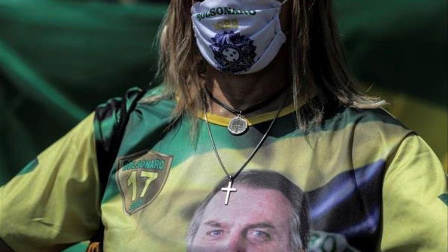 Una mujer protesta en contra de las nuevas medidas implementadas para frenar los contagios de covid-19, en la playa de Copacabana, en Río de Janeiro (Brasil).