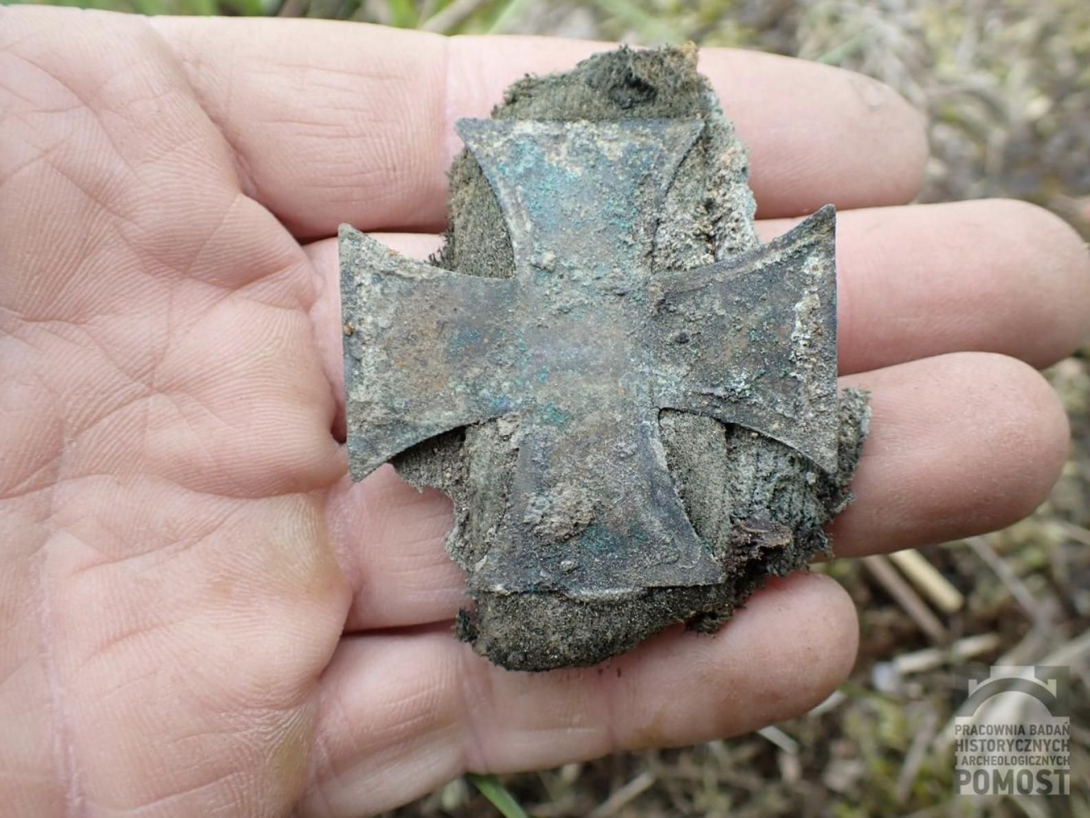 Una de las insignias encontradas en la fosa común.