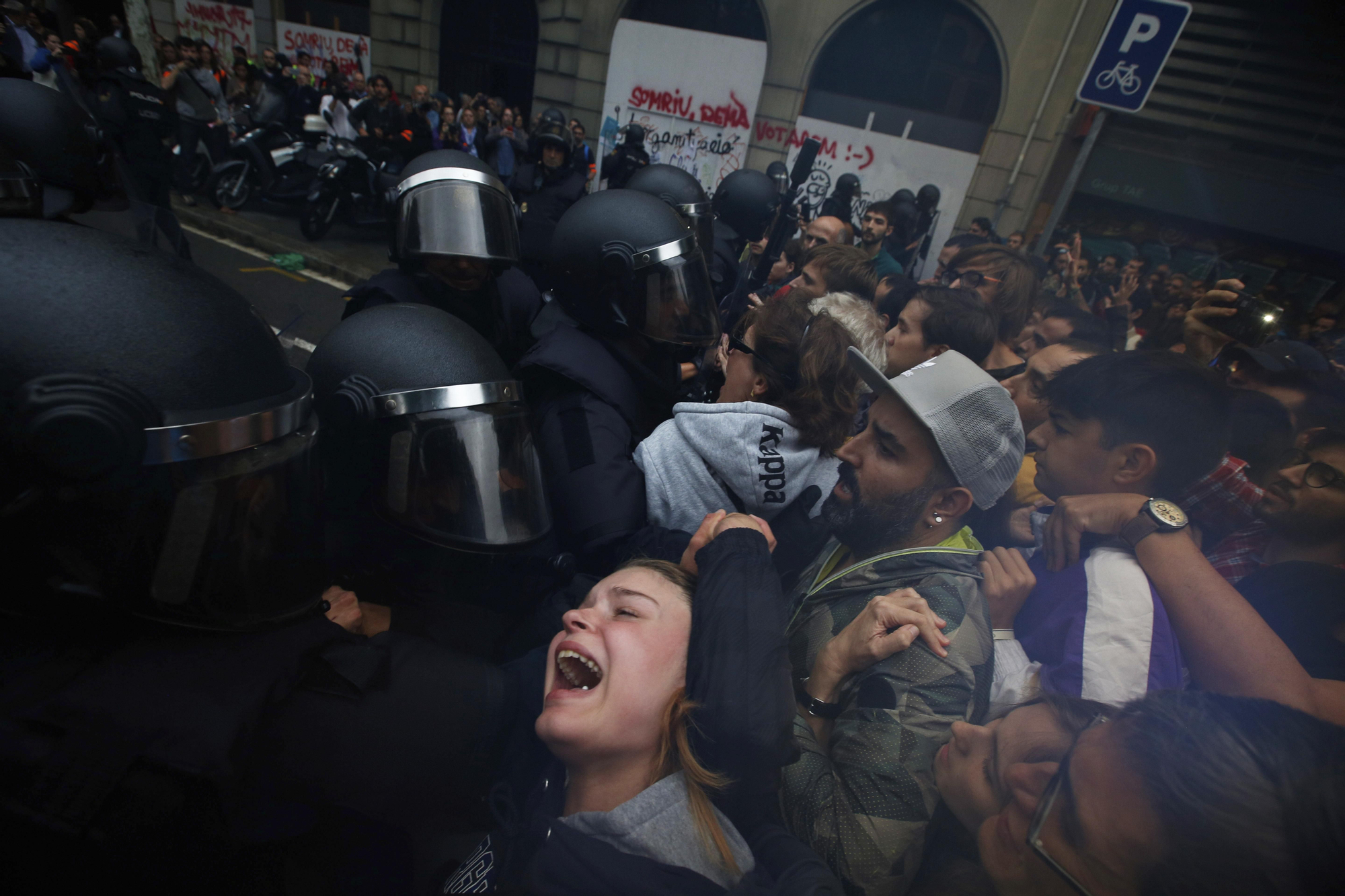 A girls grimaces as Spanish National Police pushes away Pro-referendum supporters outside the Ramon Llull school assigned to be a polling station by the Catalan government in Barcelona, Spain, early Sunday, 1 Oct. 2017. Catalan pro-referendum supporters vowed to ignore a police ultimatum to leave the schools they are occupying to use in a vote seeking independence from Spain.