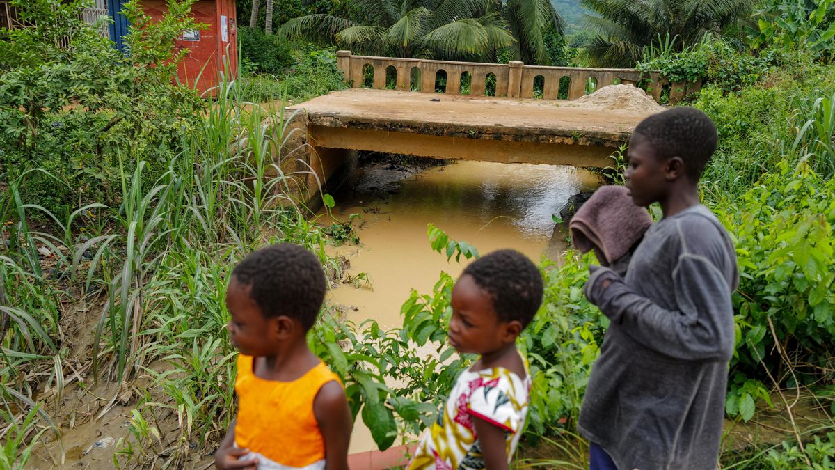 Los niños junto al arroyo Owere, con agua aparentemente contaminada por las actividades mineras ilegales denominadas localmente "galamsey" en Konongo, región de Ashanti, Ghana.