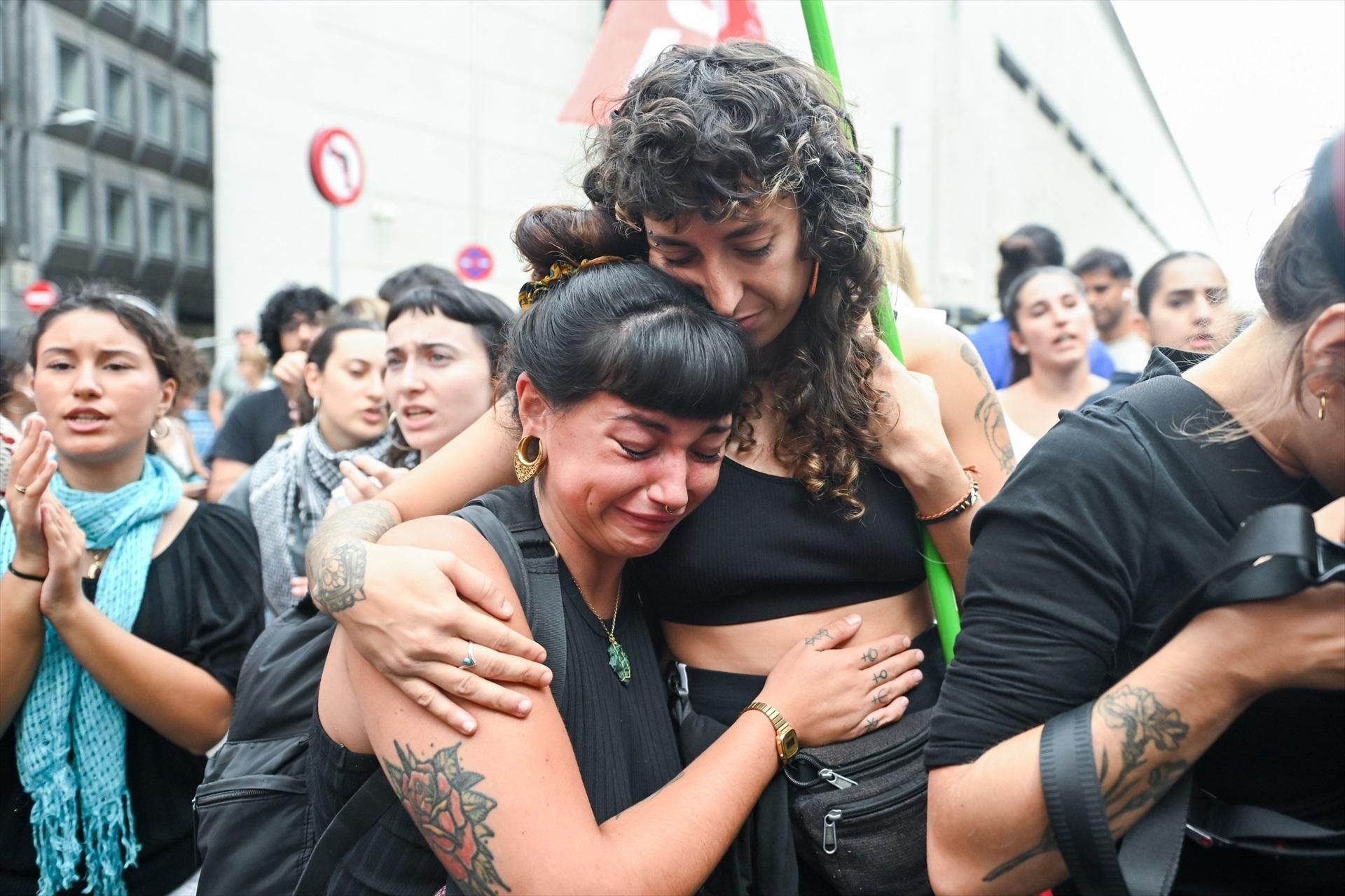 Dos jóvenes que se manifestaban en el Congreso se abrazan tras saber el resultado de la votación.