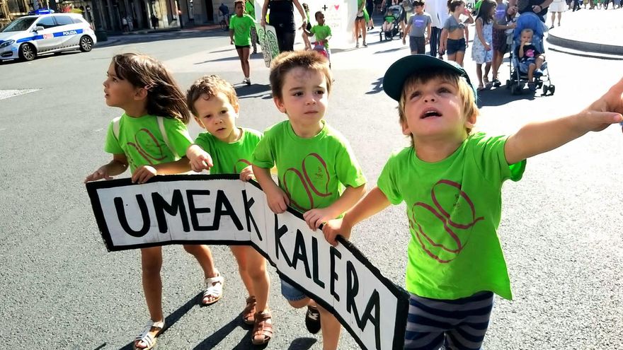 Los alumnos del colegio Mujika con un cartel en el que se lee "los niños a la calle" en euskera