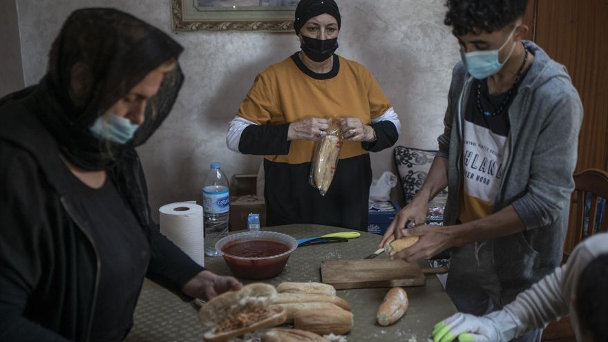 Algunos de los jóvenes llegados a Ceuta la semana pasada ayudan a preparar bocadillos para quienes acuden a casa de Sabah en busca de ayuda.