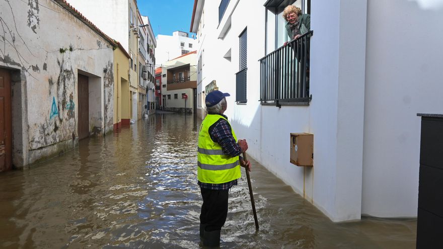 Un hombre conversa con una vecina en una calle afectada por  una inundación en el centro de Lourinha, Portugal.