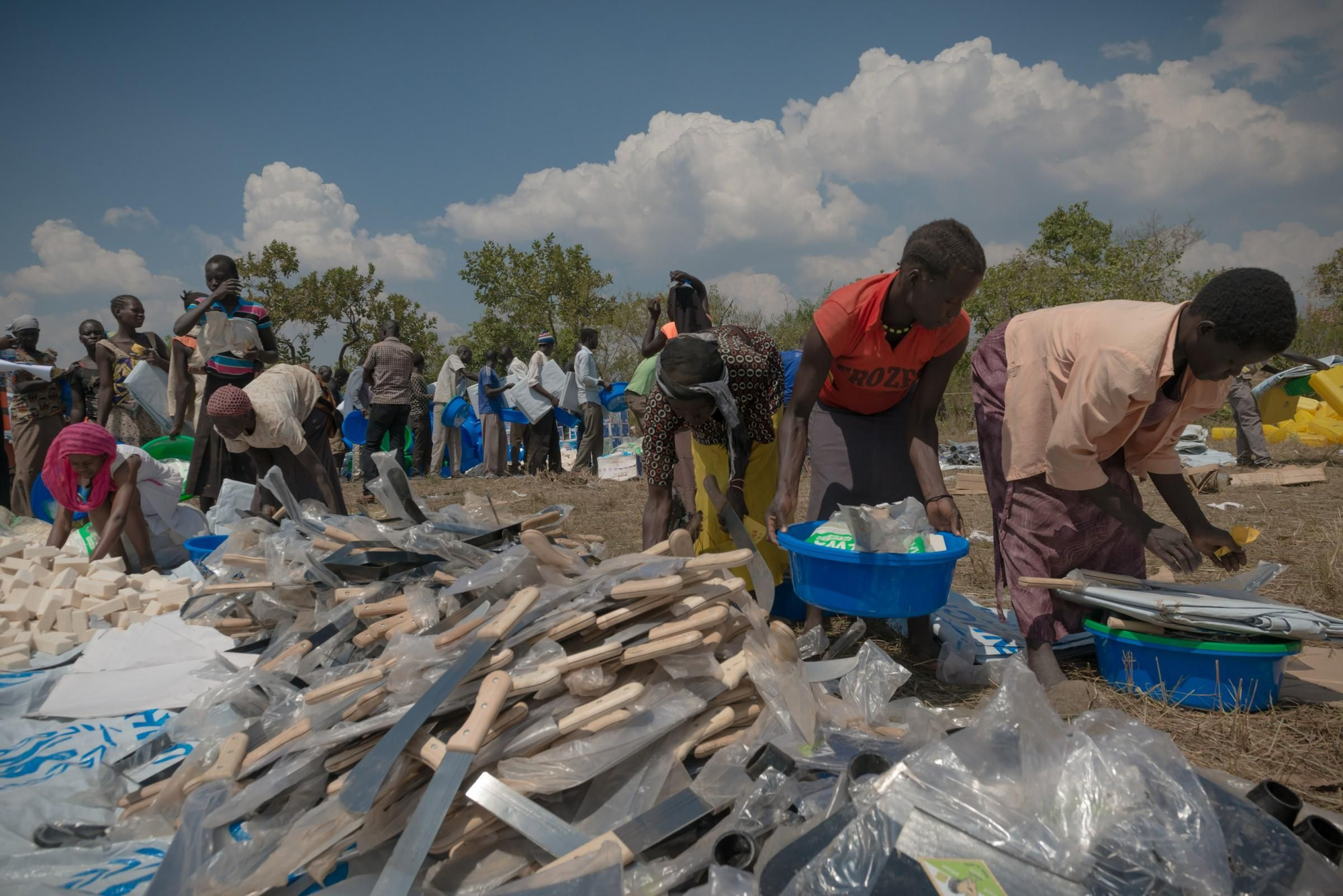 Los refugiados reciben artículos de higiene y refugio. Por lo general, los refugiados tienen que abandonar Sudán del Sur a toda prisa y no pueden llevar ninguna de sus pertenencias consigo. Uganda está asignando grandes terrenos deshabitados en el norte del país destinados a los refugiados. Inmediatamente han comenzado a cortar árboles para construir cabañas. Fotografía: Yann Libessart/MSF