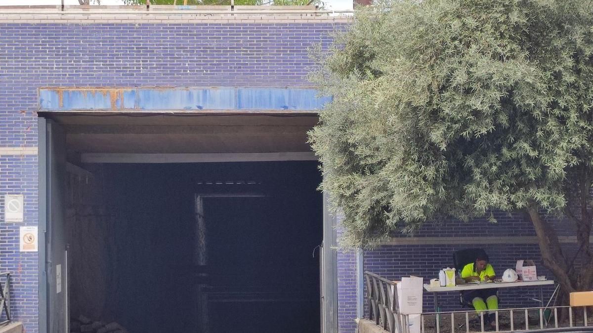 Túnel de entrada para maquinaria y operarios en la estación de Arganzuela-Planetario, con una trabajadora de la obra a la derecha.