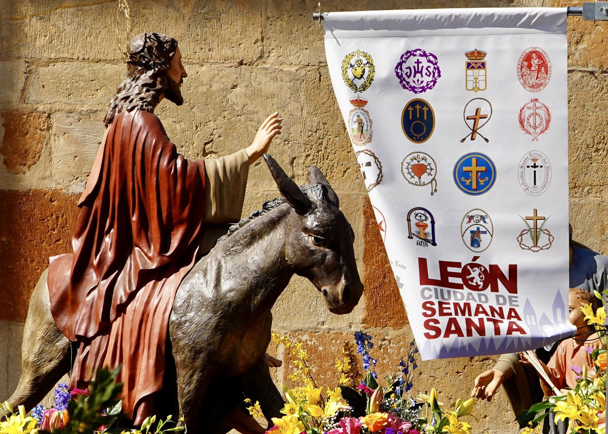 Una procesión de Las Palmas en León bajo el sol y en imágenes