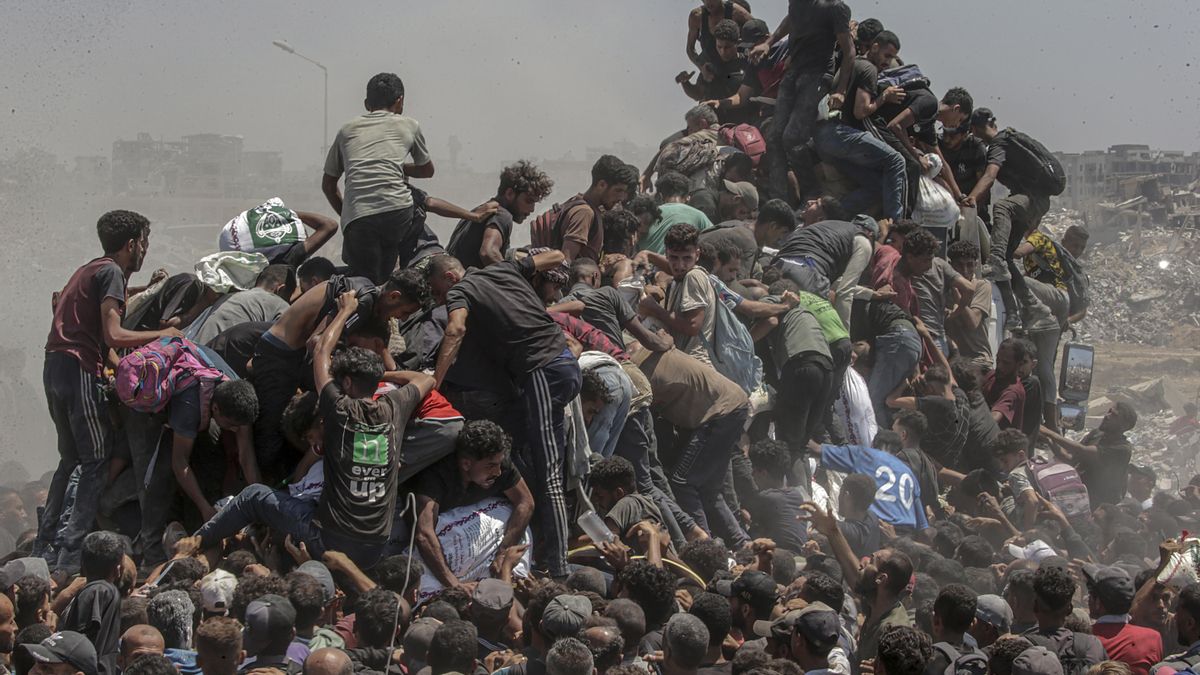 Palestinos intentan conseguir sacos de harina de un camión de ayuda cerca de un punto de distribución de alimentos en Zikim, al norte de la Franja de Gaza, este domingo. 