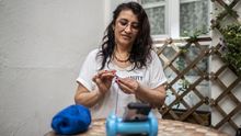 María teje ganchillo en el patio del hostal donde ha sido acogida durante el estado de alarma.