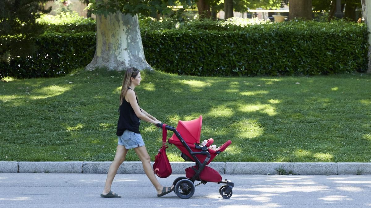 Una persona pasea con un carrito de bebé.