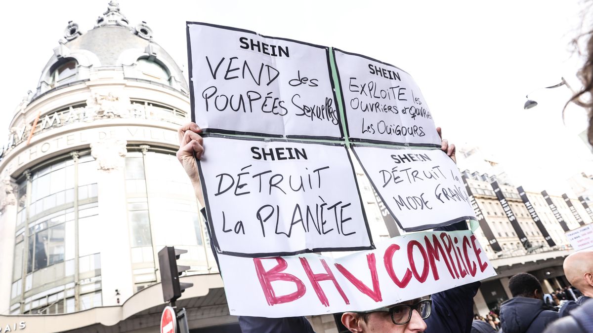 Una persona sostiene un cartel durante una manifestación contra la apertura de la primera tienda física de Shein en el edificio BHV en París