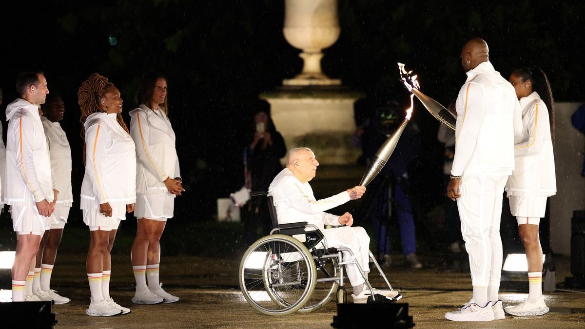 El ex ciclista Charles Coste entrega la llama olímpica a Marie-Jose Perec y Teddy Riner