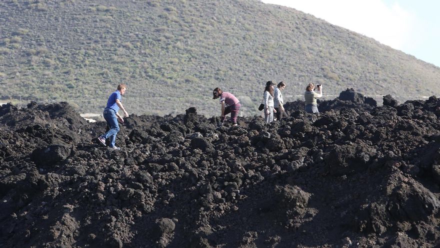 Turistas pasean por las coladas del volcán de La Palma tras la erupción