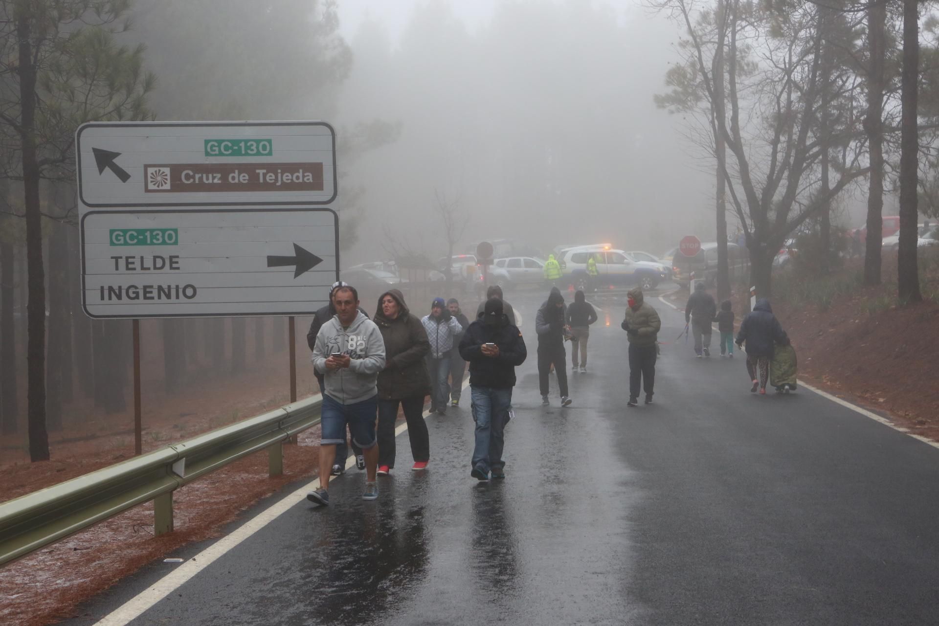 Un grupo de personas se acerca a apreciar la nieve que ha caído en la cumbre de Gran Canaria.