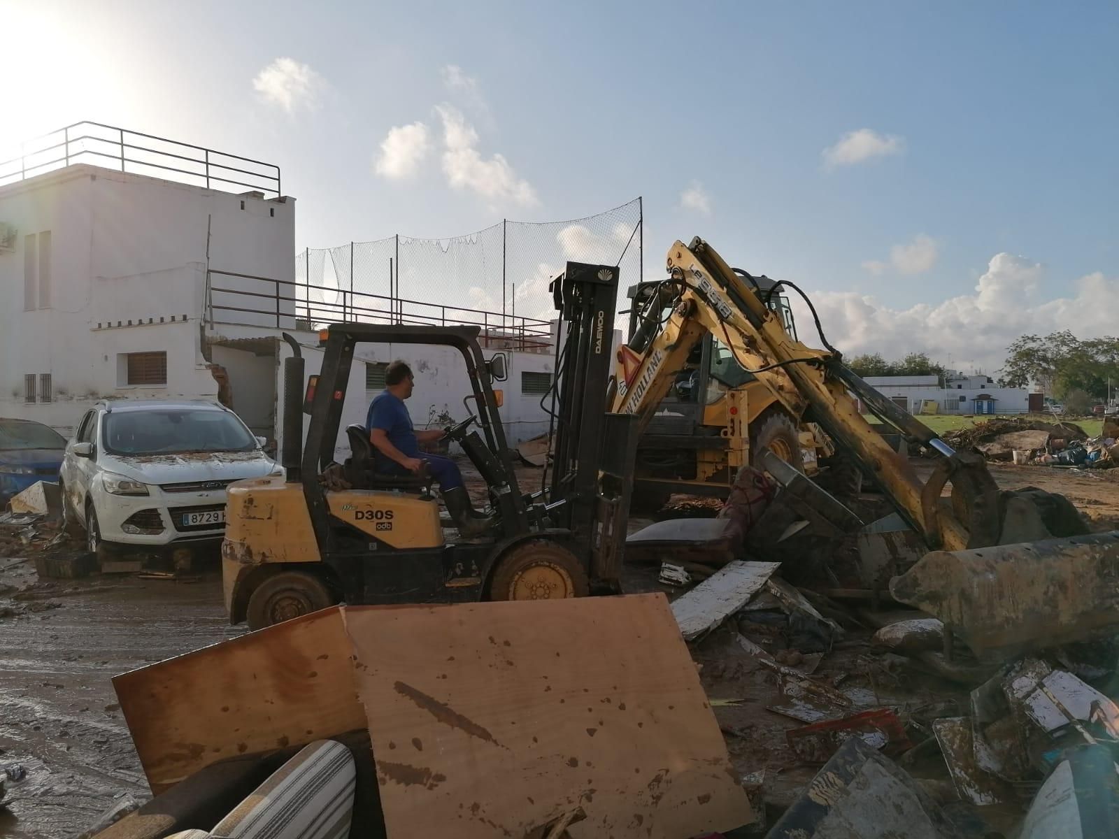 Una excavadora recoge lo que ha arrastrado el agua junto al campo de fútbol de Lepe