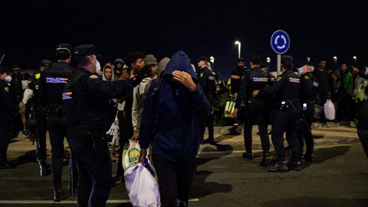 Decenas de migrantes esperan en Loma Colmenar mientras la Policía Nacional los dirige a un nuevo emplazamiento.